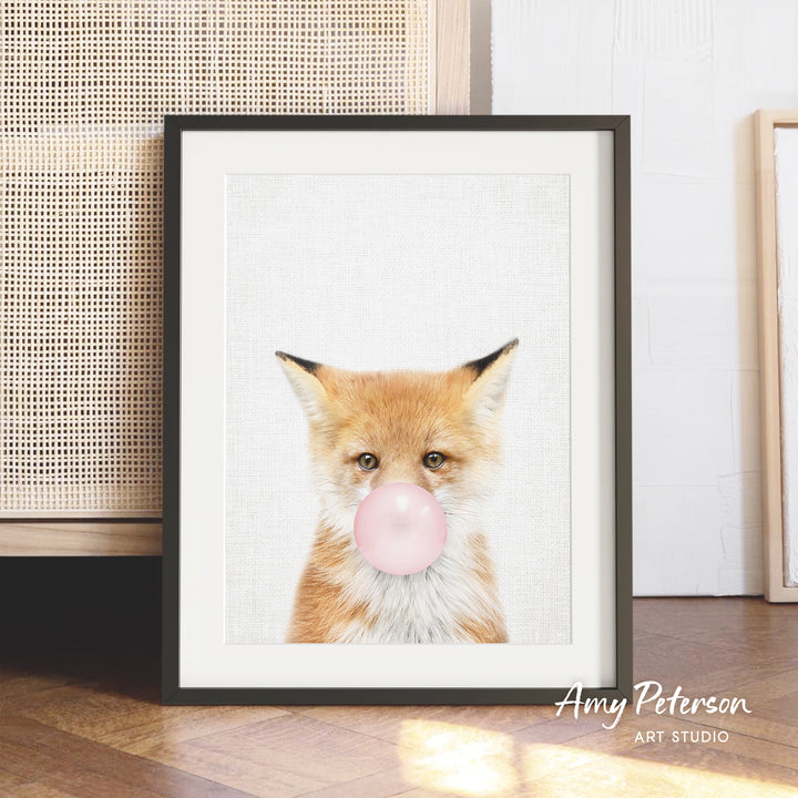 A framed print of a fox blowing a bubble with a pink bubble gum bubble.