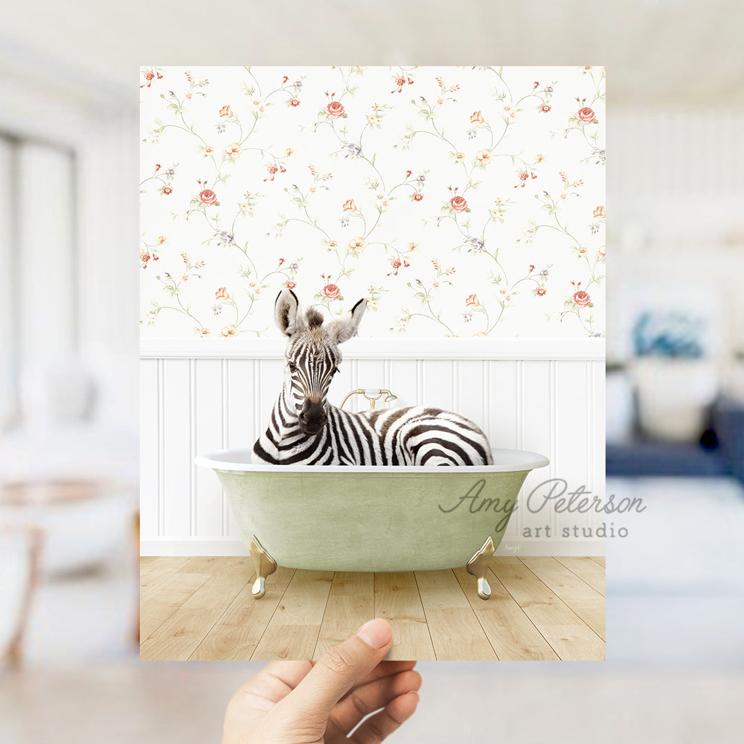 a hand holding up a picture of a zebra in a bathtub