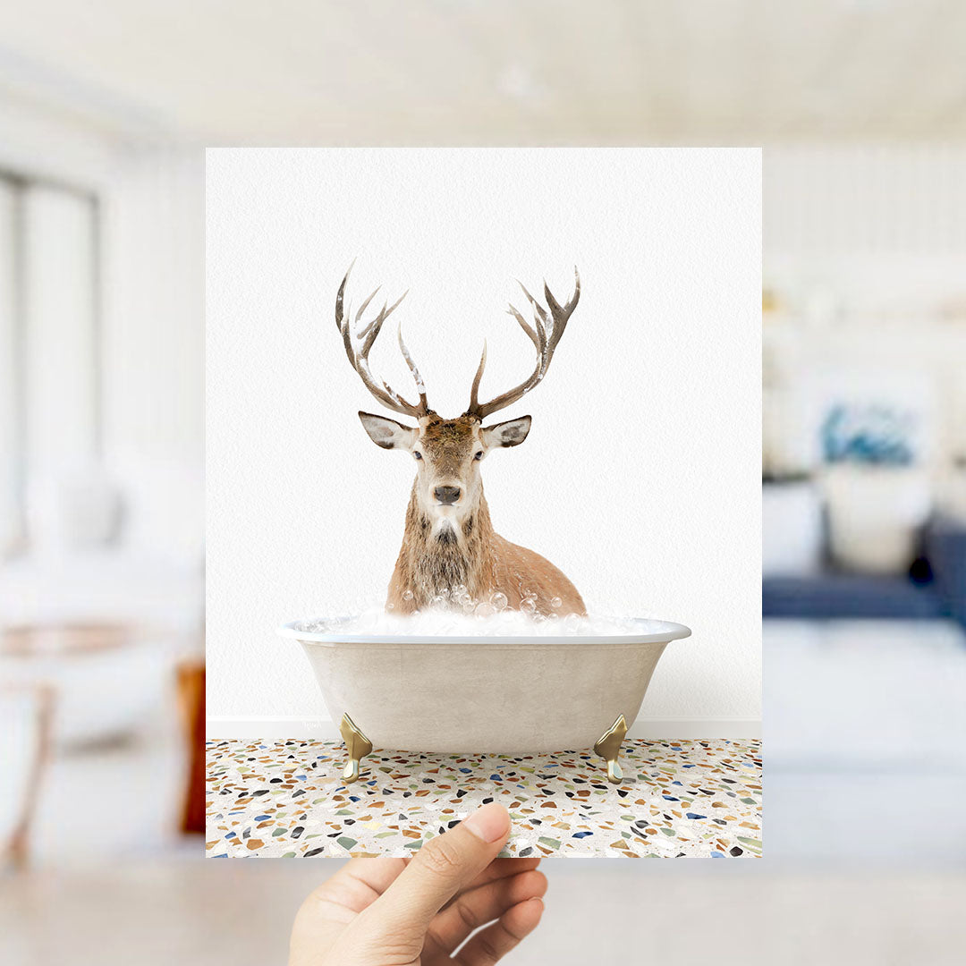 A deer with large antlers is sitting in a bathtub filled with water, creating a whimsical and unexpected scene.