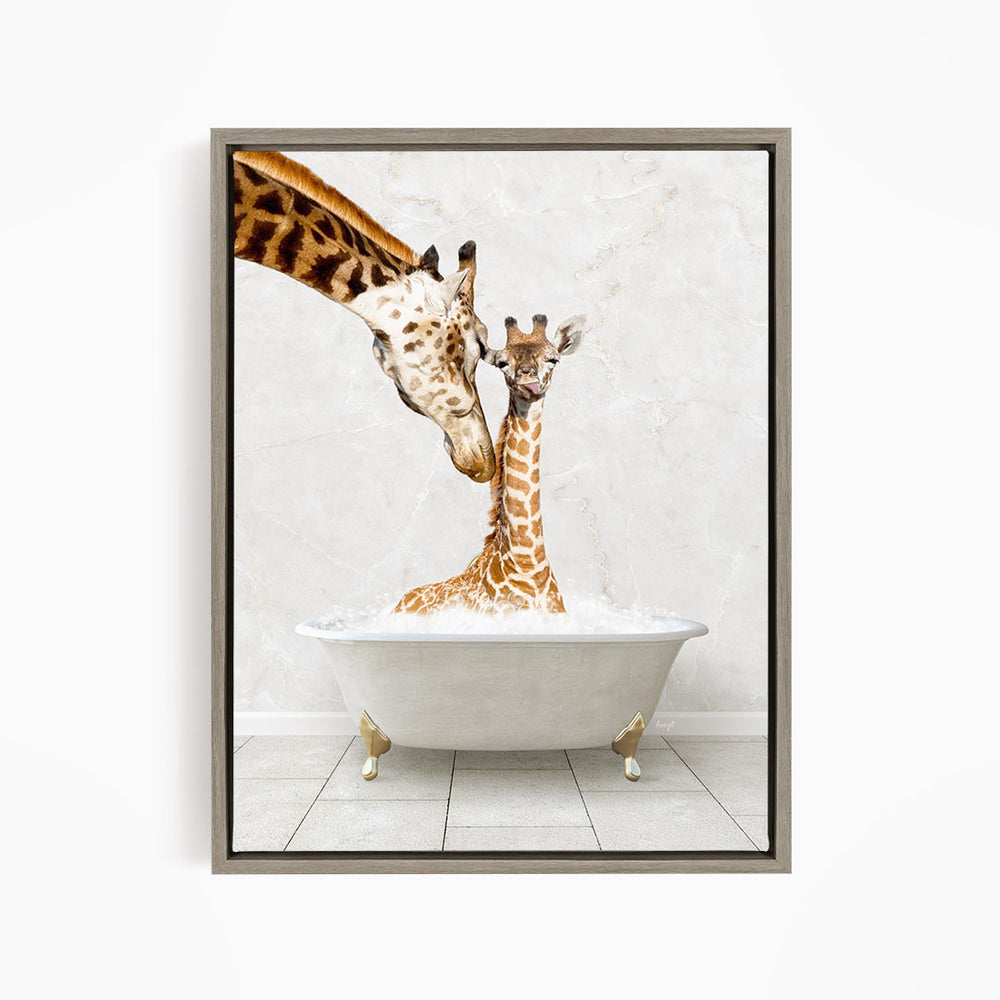 A mother giraffe and her baby giraffe are sitting together in a white bathtub, with the mother gently licking her baby.