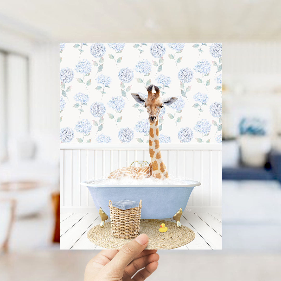 A giraffe sitting in a blue bathtub filled with bubbles, surrounded by a wicker basket and a rubber duck.