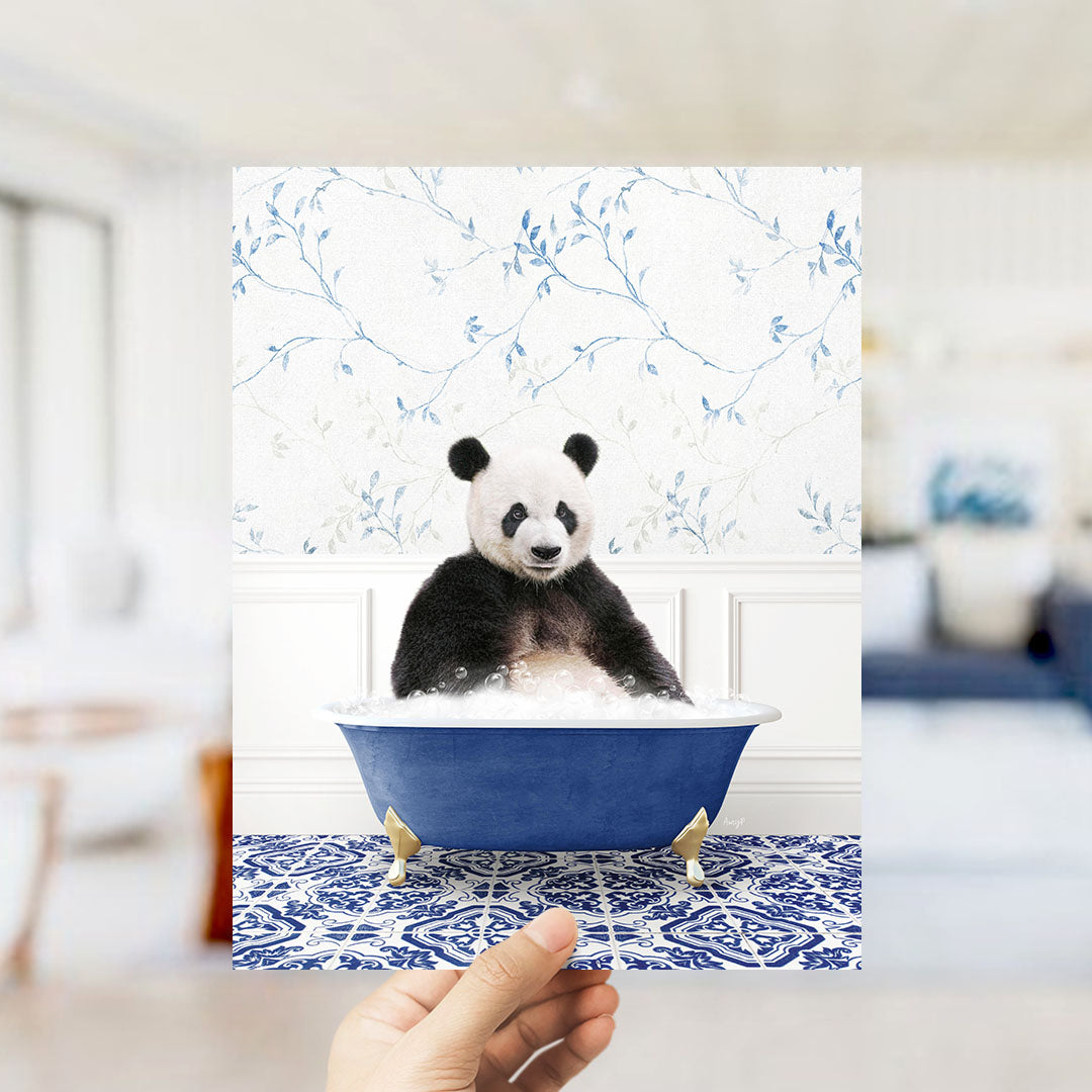 A panda bear sitting in a blue bathtub filled with bubbles, surrounded by a blue and white floral patterned wall.