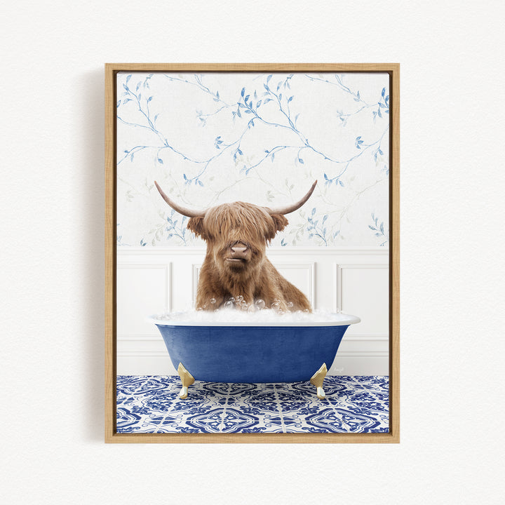 A brown cow with long horns is sitting in a blue bathtub, surrounded by a blue and white patterned rug.