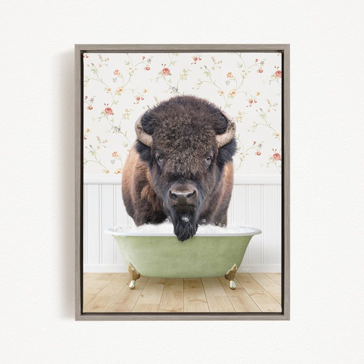A bison with a long beard is sitting in a green bathtub, with a floral wallpaper in the background.