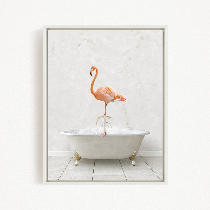 A pink flamingo standing on the edge of a white bathtub filled with bubbles.