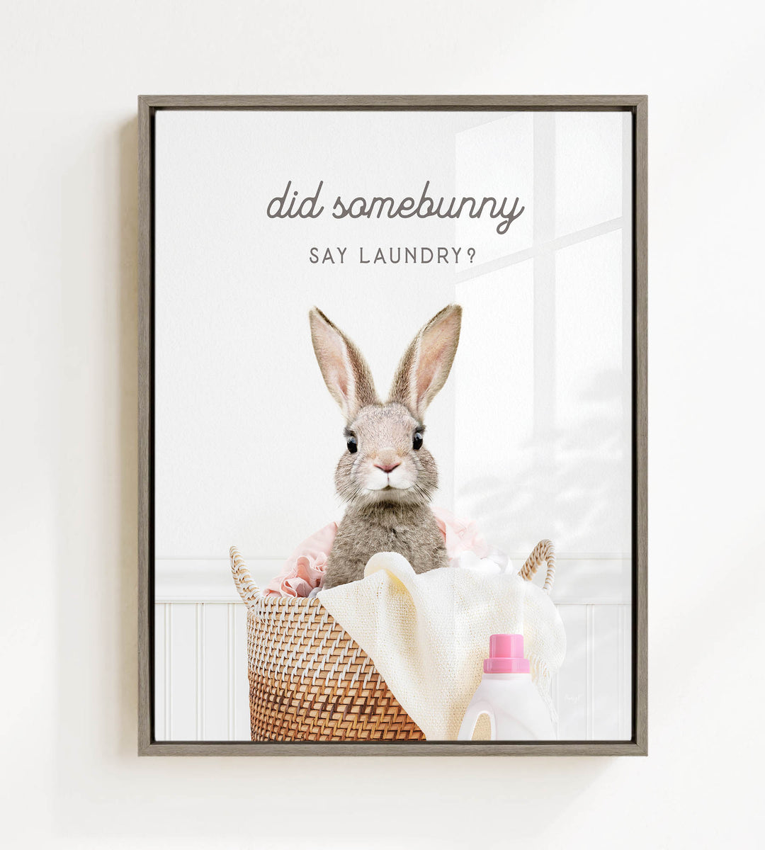 A framed image of a rabbit sitting in a laundry basket, with a bottle of laundry detergent next to it. The text above the rabbit reads "did somebunny say laundry?".