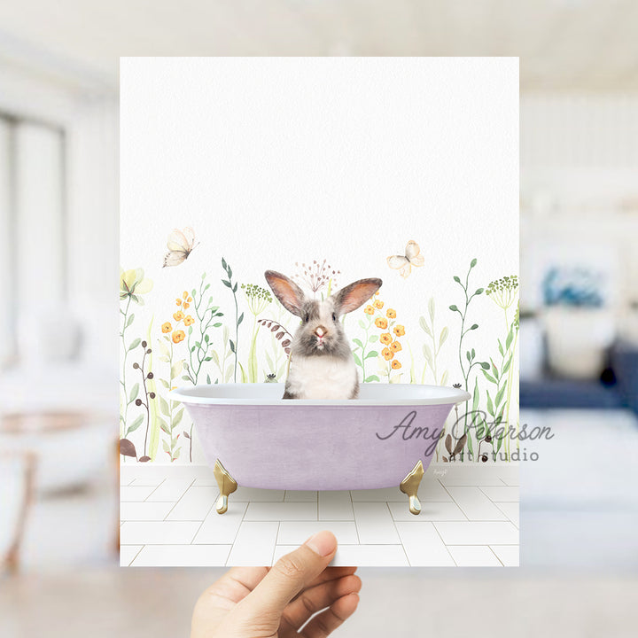 a person holding up a card with a picture of a bunny in a bathtub