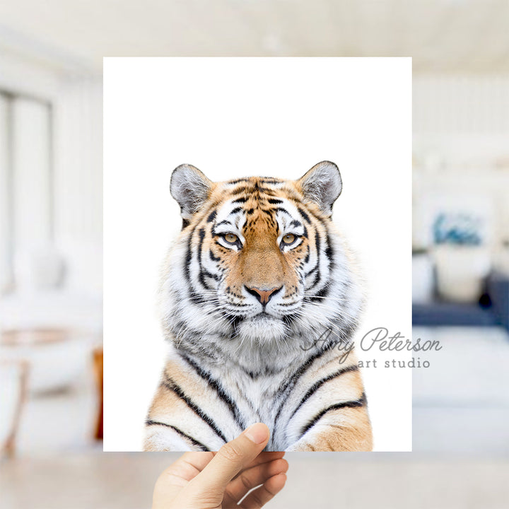 a hand holding up a picture of a tiger