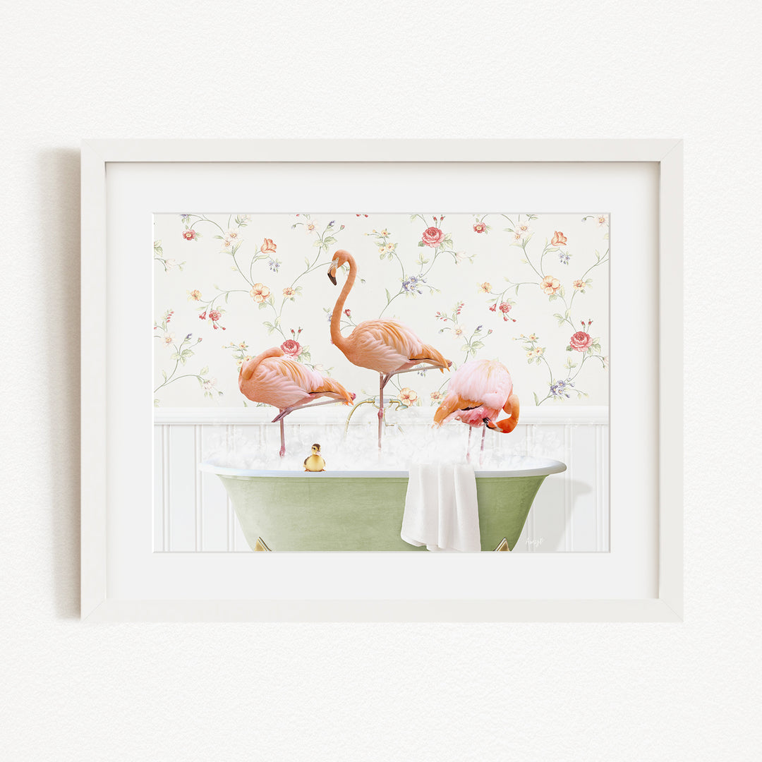 A framed image depicting three pink flamingos standing in a green bathtub filled with water, surrounded by a floral patterned wallpaper.