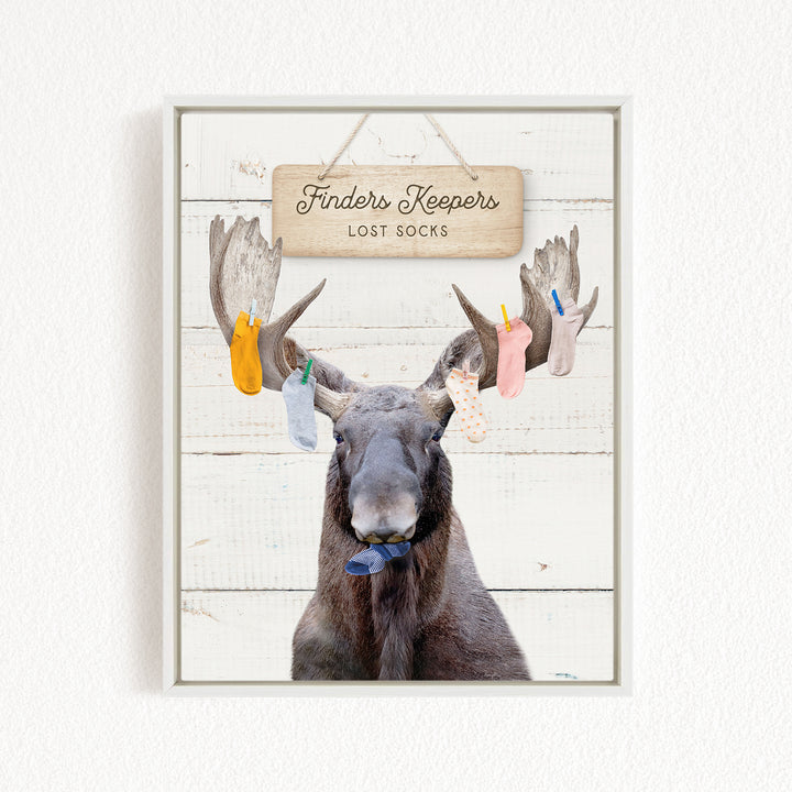 A framed image of a moose with a sign that reads "Finders Keepers Lost Socks" hanging above it.