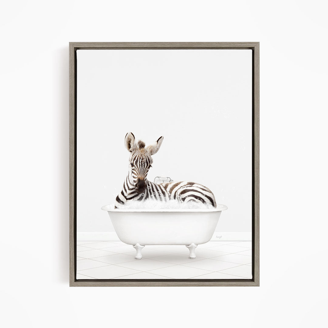 A zebra lying in a white bathtub, surrounded by bubbles.