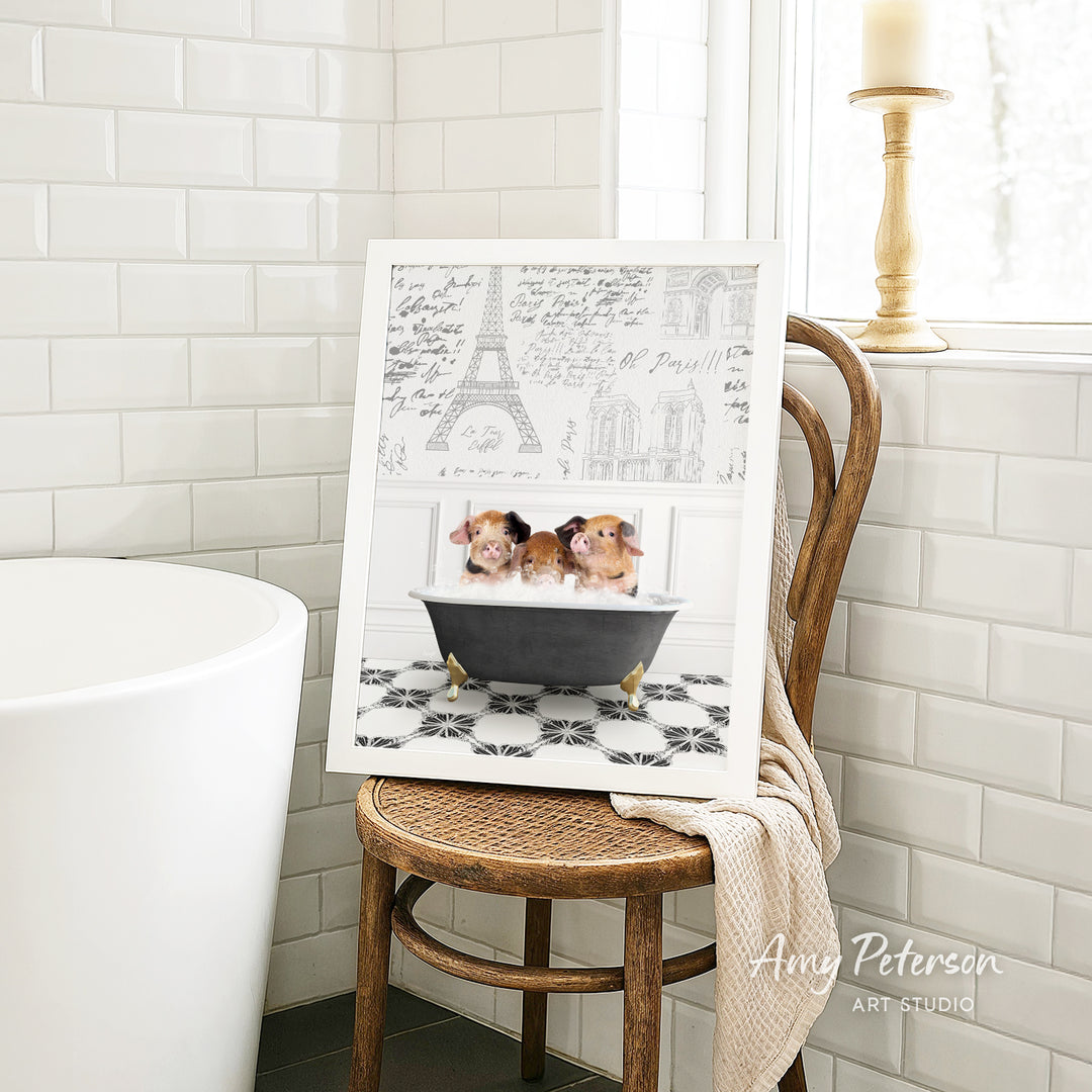 A framed image of two small dogs sitting in a bathtub, with a drawing of the Eiffel Tower in the background.