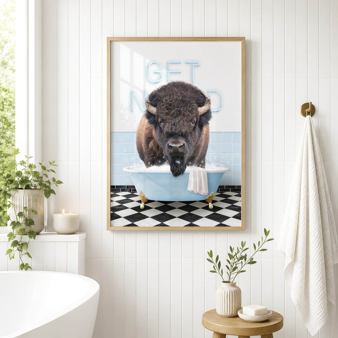 a framed picture of a buffalo sitting in a bathtub, with the words "GET NUD" written on the wall behind it.