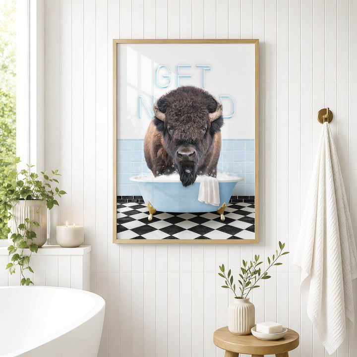 a framed picture of a buffalo sitting in a bathtub, with the words "GET NUD" written on the wall behind it.