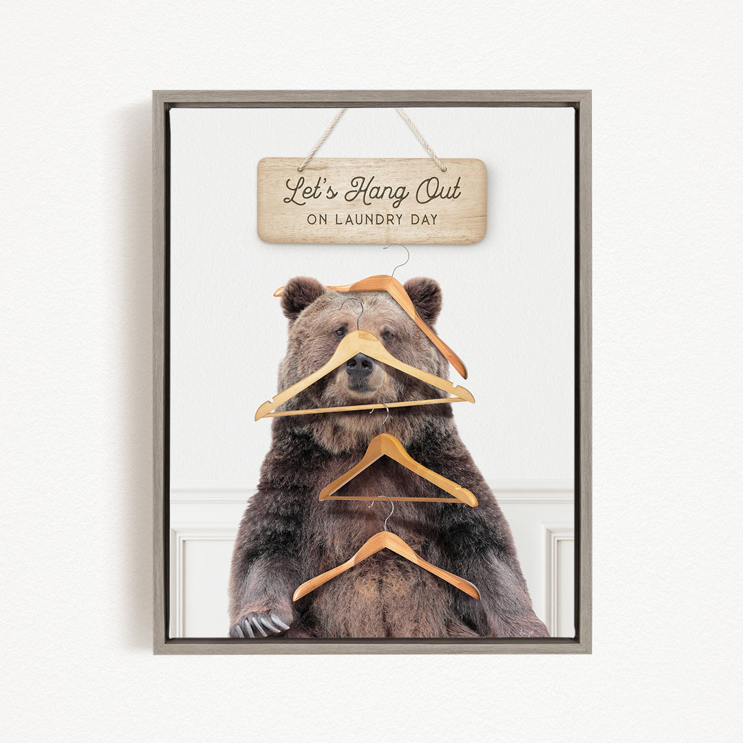 A framed image of a bear sitting in front of a sign that says "Let's Hang Out on Laundry Day".