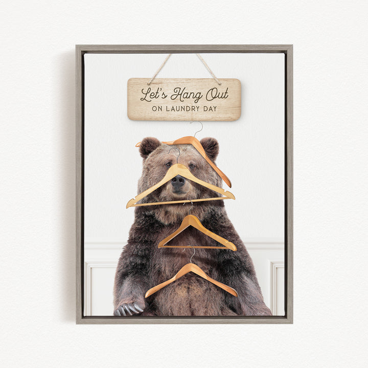 A framed image of a bear sitting in front of a sign that says "Let's Hang Out on Laundry Day".