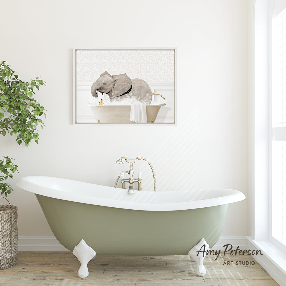 A framed image of an elephant sitting in a bathtub is displayed on the wall above a green clawfoot bathtub in a bathroom.