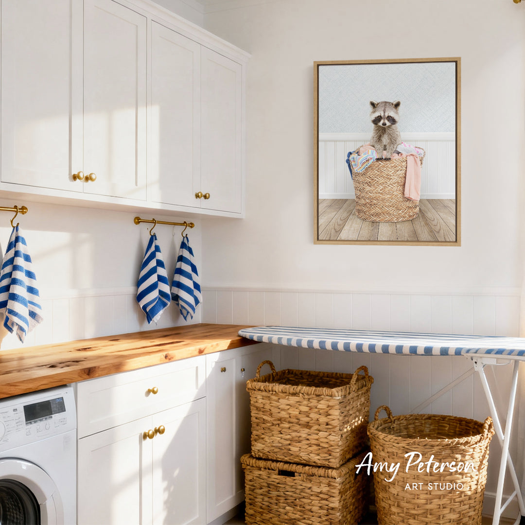 A laundry room with white cabinets, a wooden countertop, and a framed picture of a raccoon sitting in a basket.