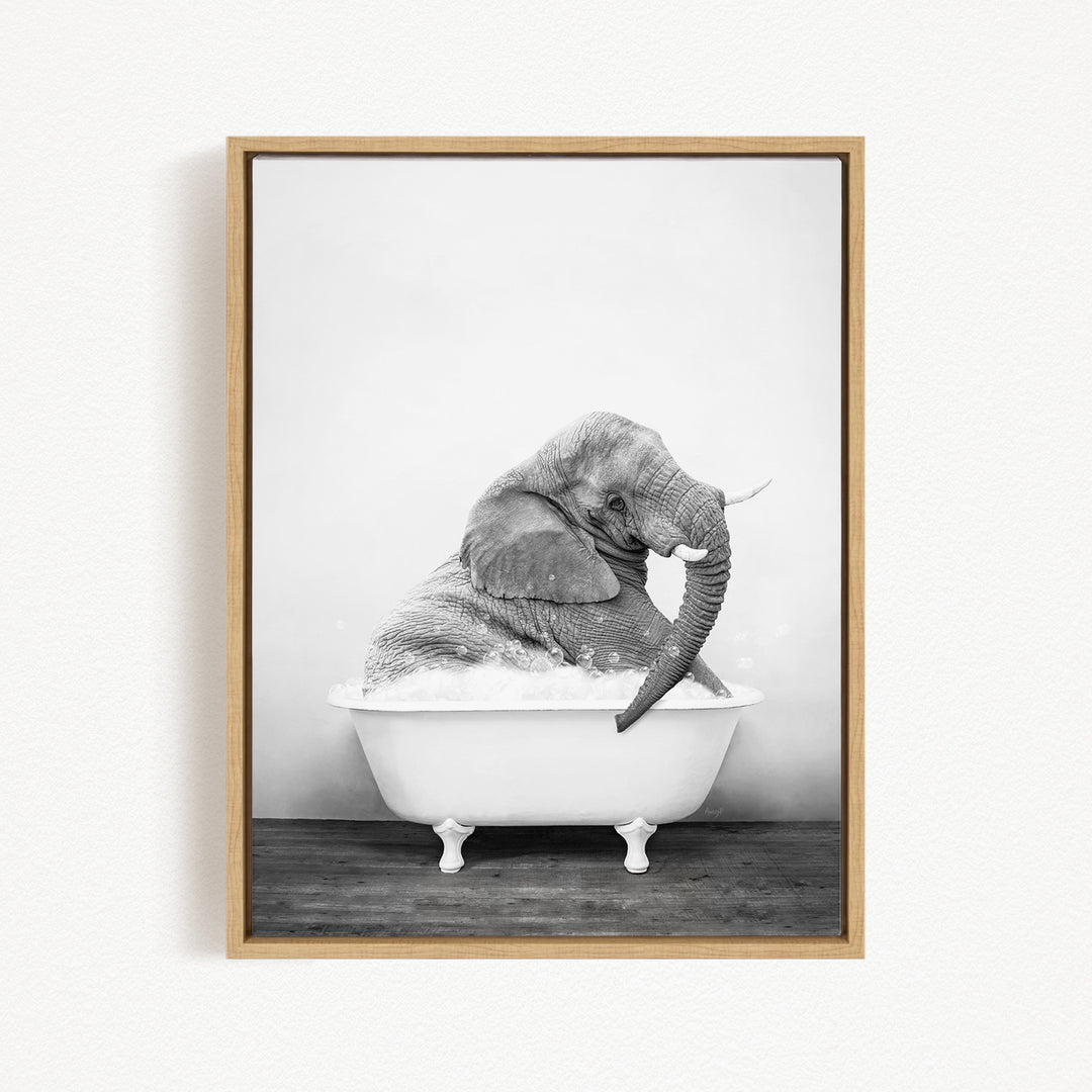 A black and white photograph of an elephant sitting in a bathtub filled with water.