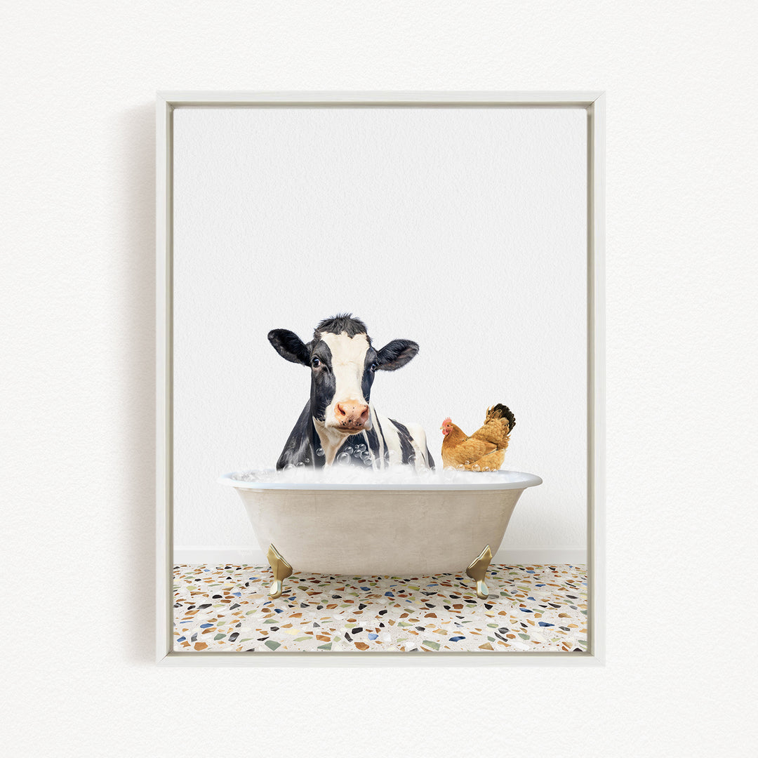 A black and white cow is sitting in a white bathtub, with a chicken standing nearby, both appearing to enjoy the bath together.