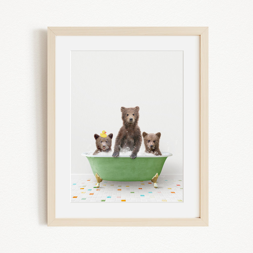 A framed image depicting three adorable brown bears sitting in a green bathtub filled with water, surrounded by colorful tiles on the floor.
