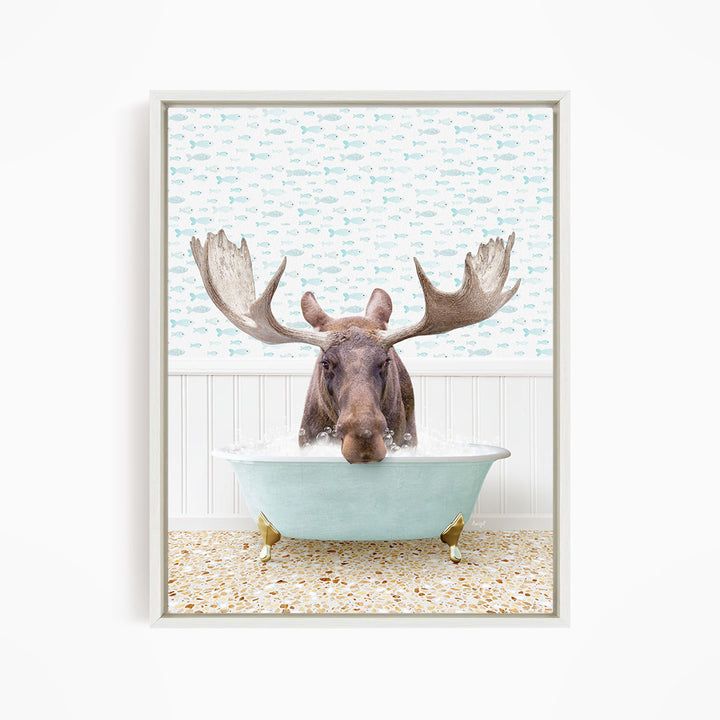 A moose with large antlers is sitting in a light blue bathtub filled with water, surrounded by a pattern of small fish.