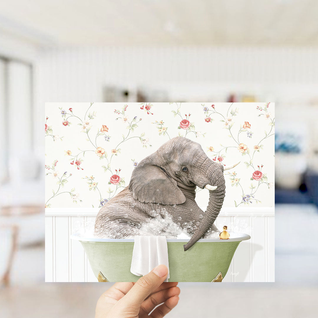 A hand holds up a collage of two images: one showing an elephant sitting in a bathtub with a yellow rubber duck, and the other depicting a floral wallpaper.