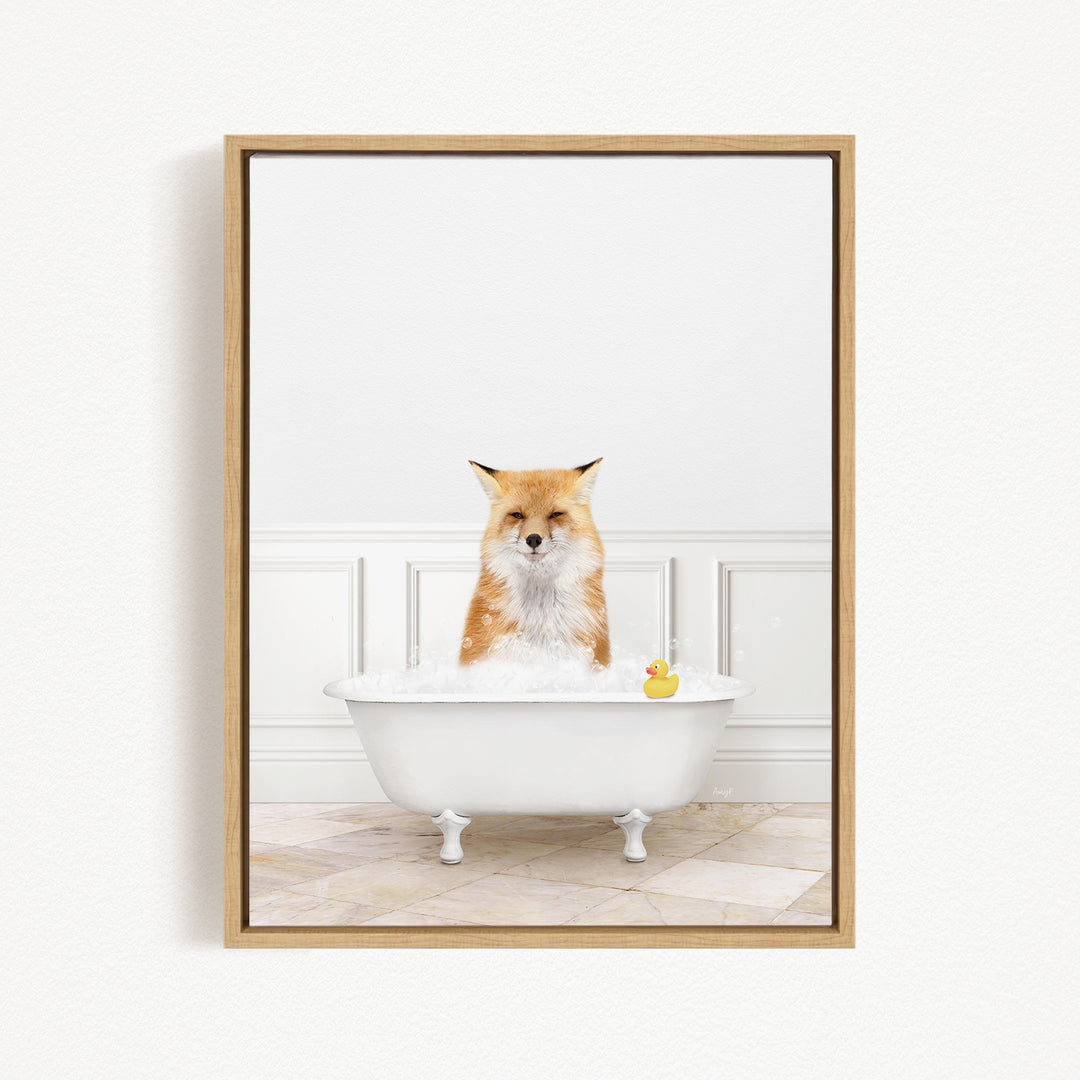 A red fox is sitting in a white bathtub filled with bubbles, with a rubber duck floating in the water.