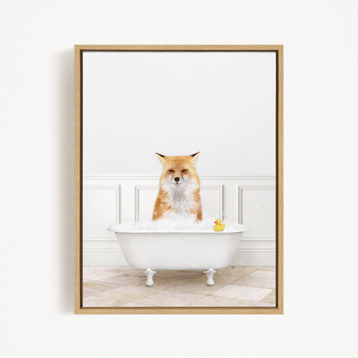 A red fox is sitting in a white bathtub filled with bubbles, with a rubber duck floating in the water.