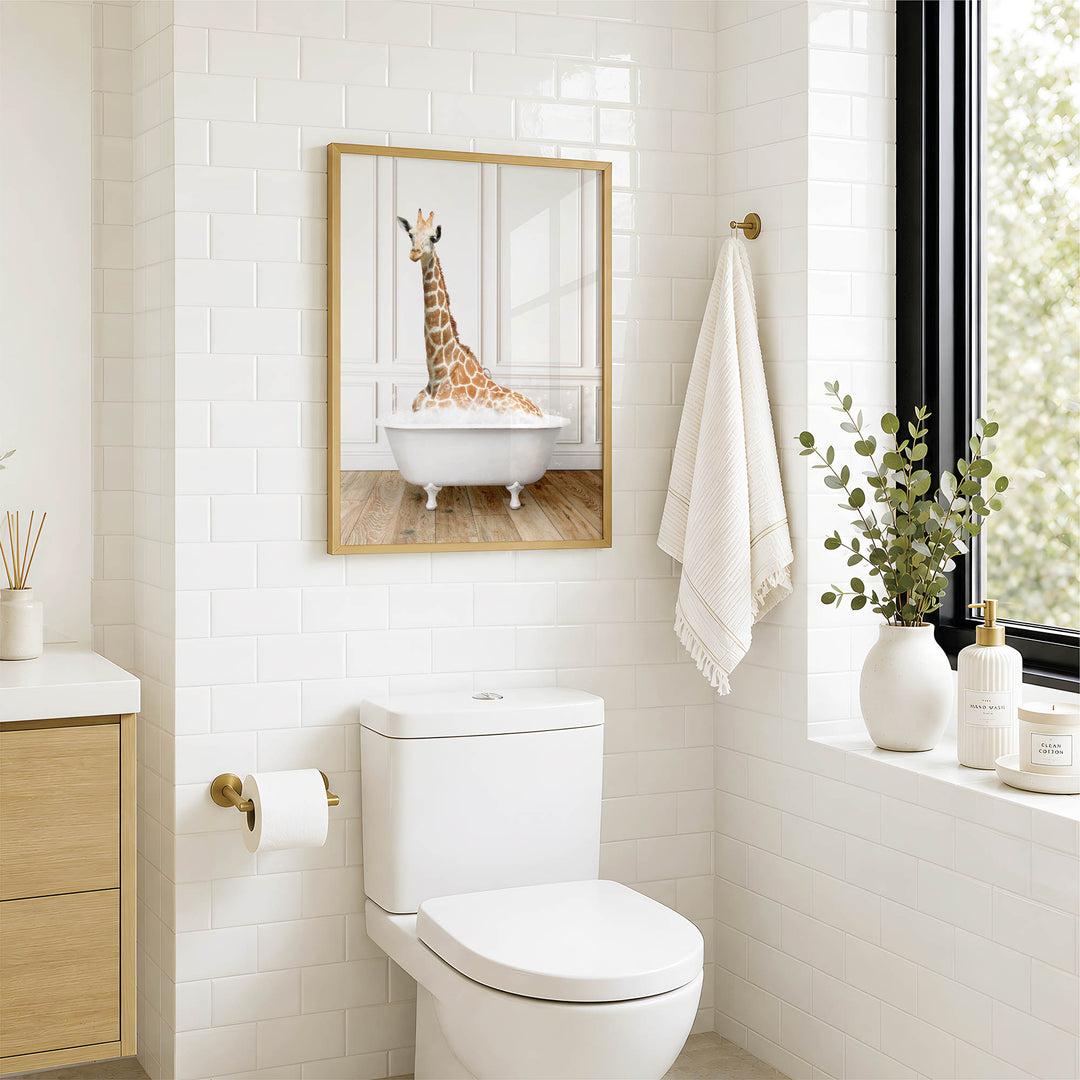 A bathroom with a white toilet, a framed image of a giraffe in a bathtub, and a window with greenery on the sill.