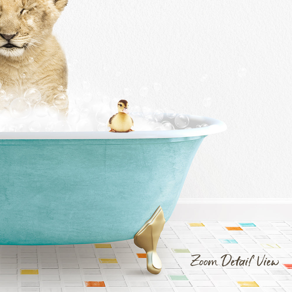 A lion cub is taking a bath in a blue bathtub, with a small yellow duck sitting on the edge of the tub.