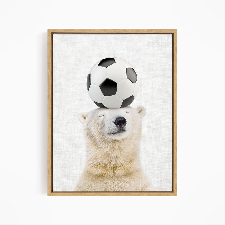 A polar bear balancing a soccer ball on its head.