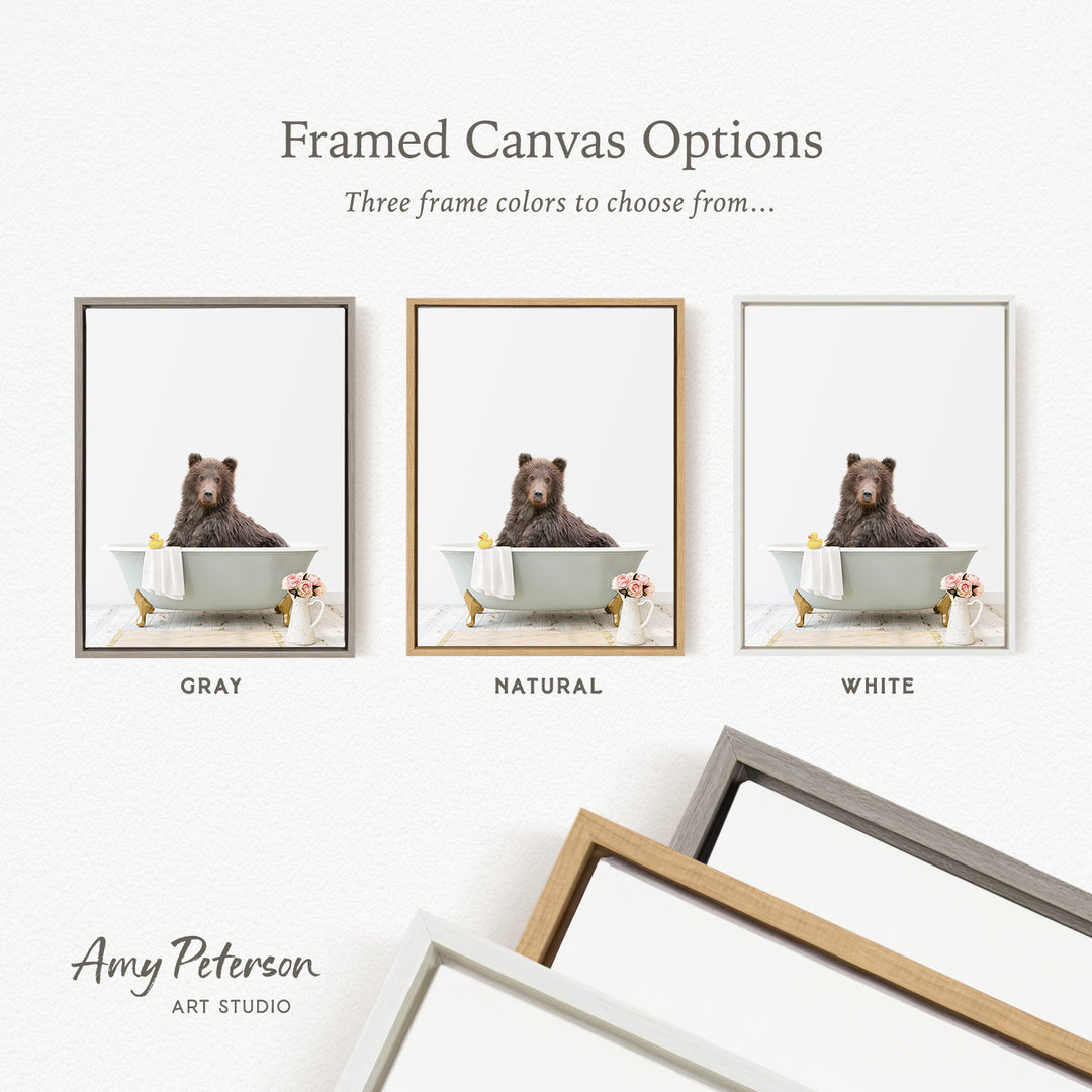 three framed canvas options, each featuring a brown bear sitting in a bathtub. The options include a gray frame, a natural frame, and a white frame.