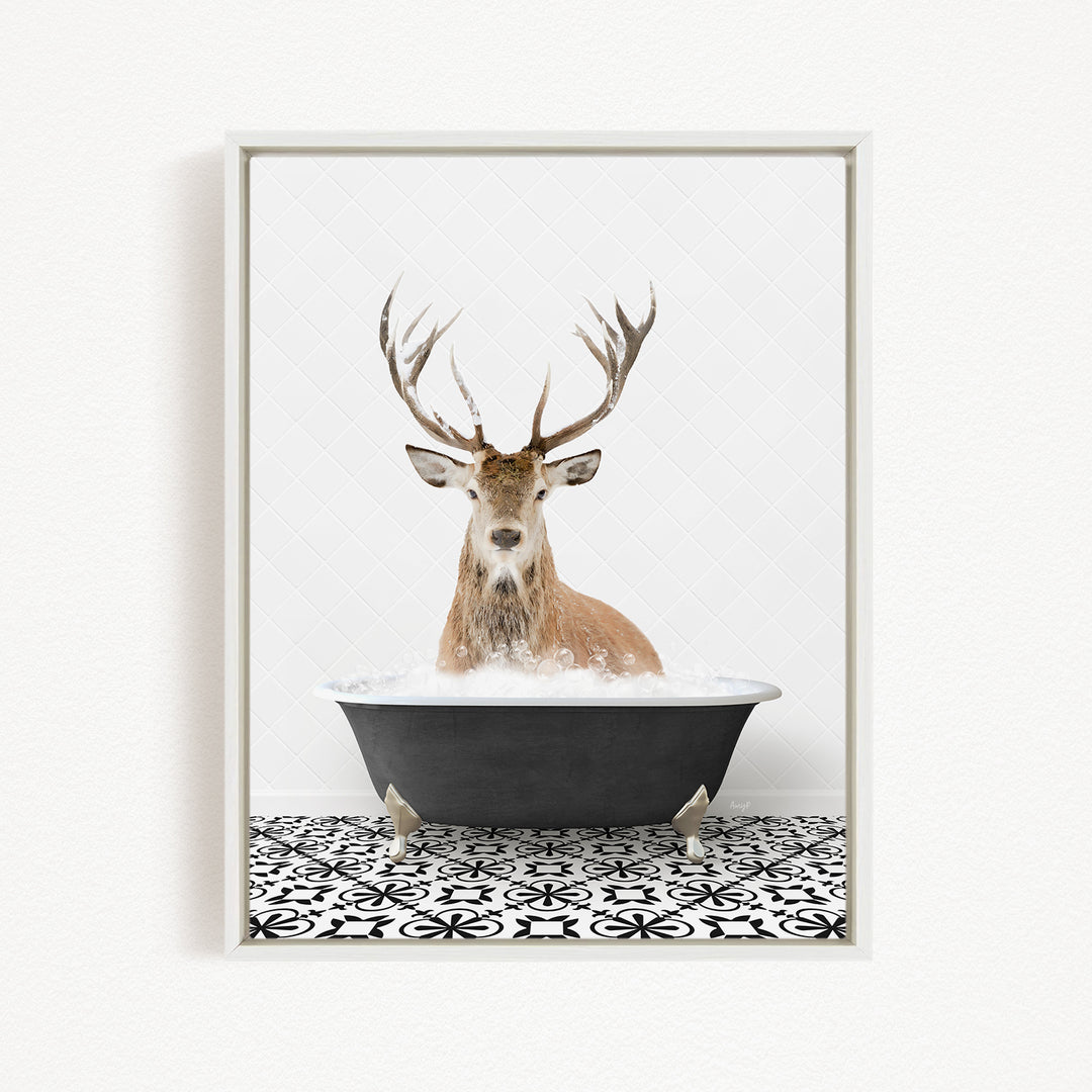 A deer with large antlers is sitting in a black bathtub filled with water, creating a whimsical and unexpected scene.