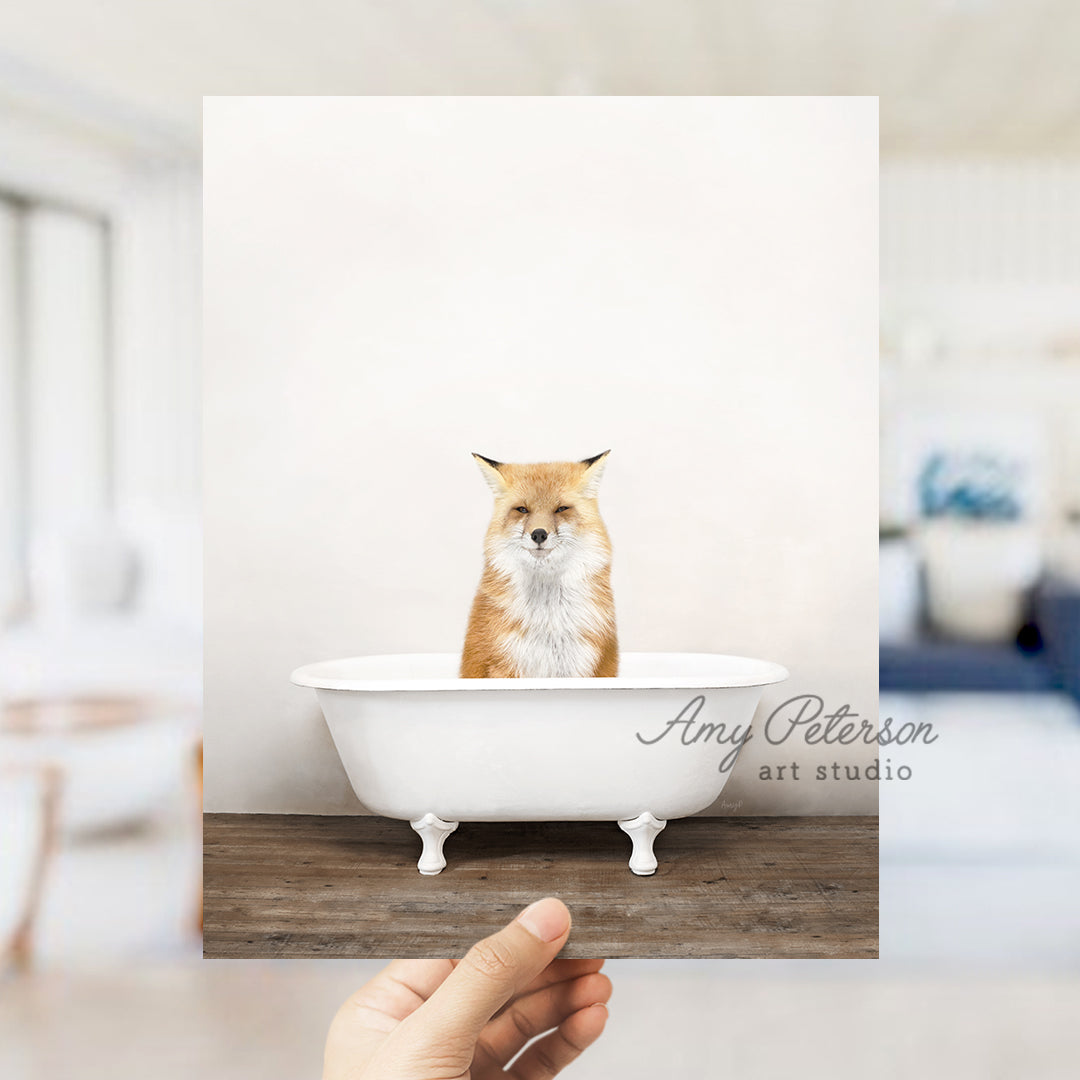 a hand holding up a photo of a fox in a bathtub