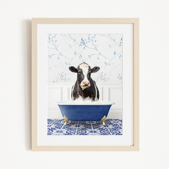 A black and white cow is sitting in a blue bathtub filled with water, creating a whimsical and humorous scene.