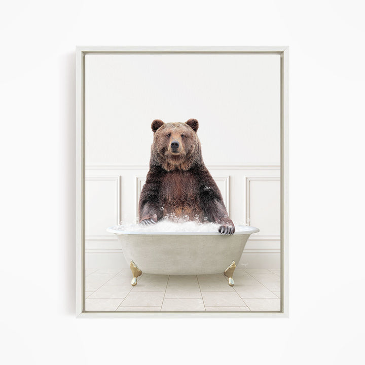 A brown bear sitting in a white bathtub filled with water, appearing to enjoy the bath.
