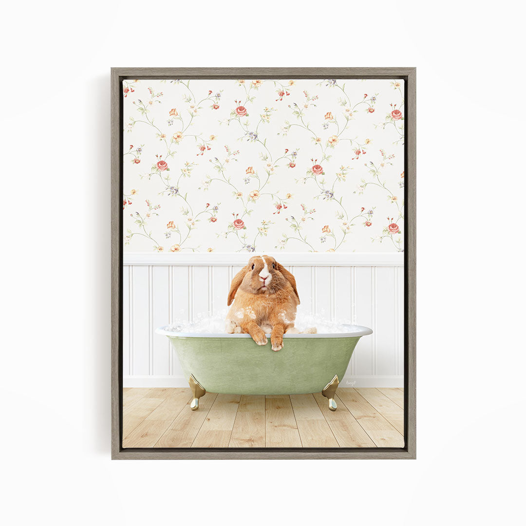 A brown rabbit sitting in a green bathtub filled with water, with a floral wallpaper in the background.