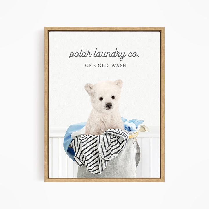 A white polar bear sitting in a laundry basket filled with clothes, with the text "polar laundry co. ICE COLD WASH" displayed above the image.