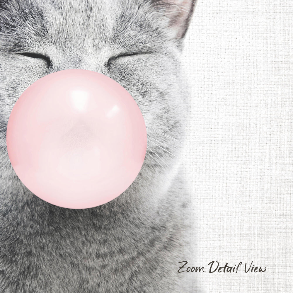 A gray cat is blowing a pink bubble with its mouth, creating a playful and whimsical scene.