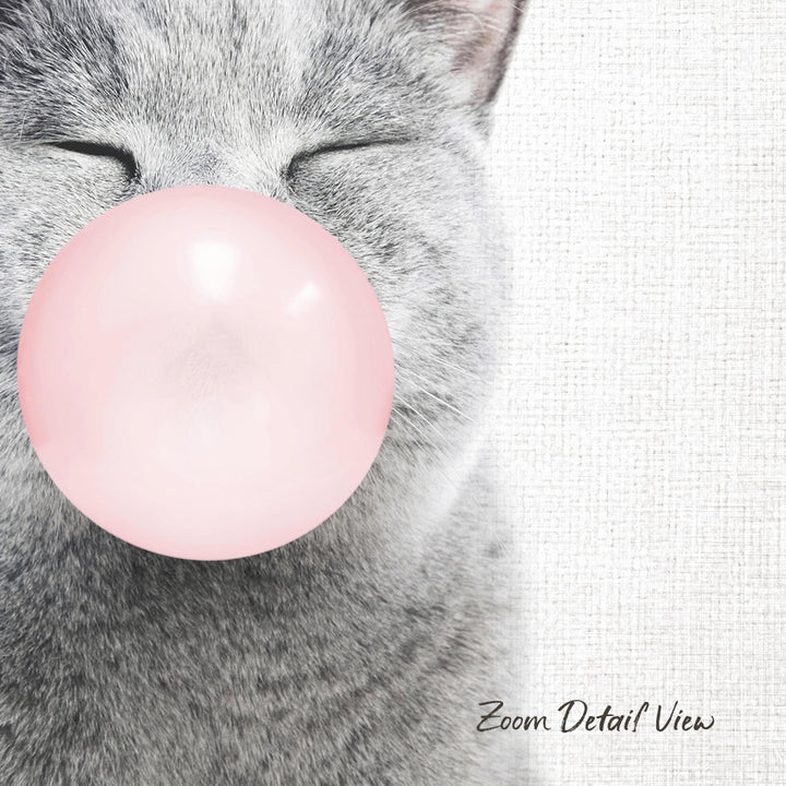 A gray cat is blowing a pink bubble with its mouth, creating a playful and whimsical scene.