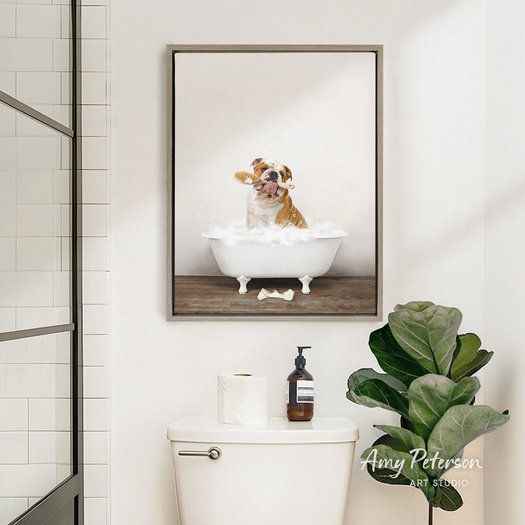 A framed image of a dog sitting in a bathtub, surrounded by bubbles, is displayed on the wall above a white toilet in a bathroom.