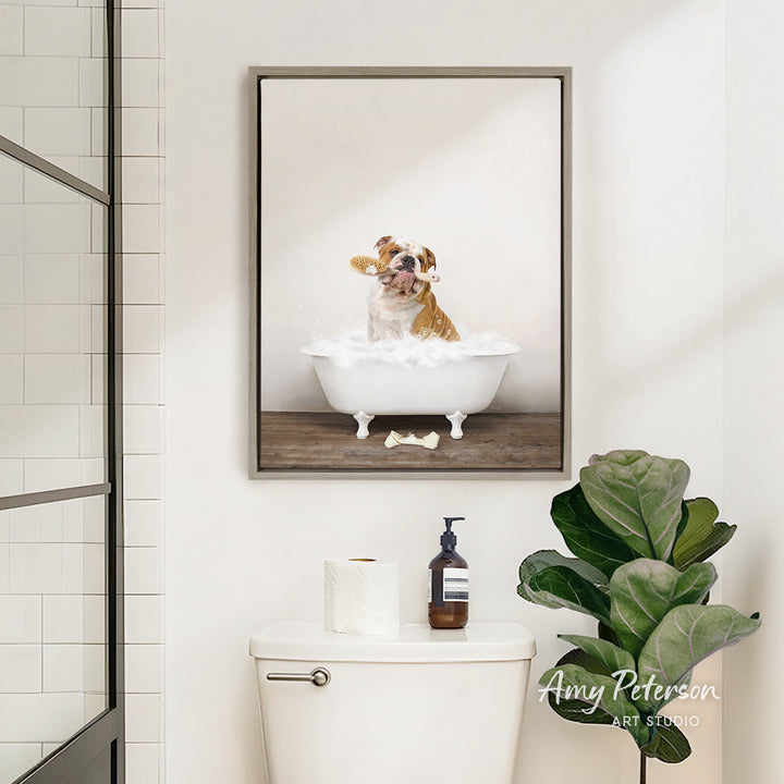 A framed image of a dog sitting in a bathtub, surrounded by bubbles, is displayed on the wall above a white toilet in a bathroom.