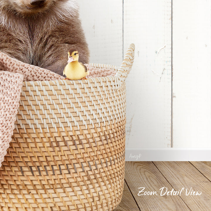 A small yellow duck sits in a woven basket, with a brown bear sitting next to it.