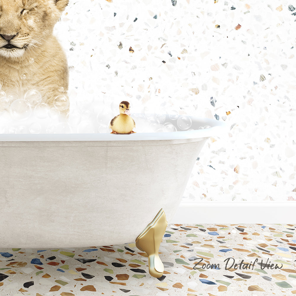 A lion cub is taking a bath in a bathtub, with a small duck sitting on the edge of the tub.