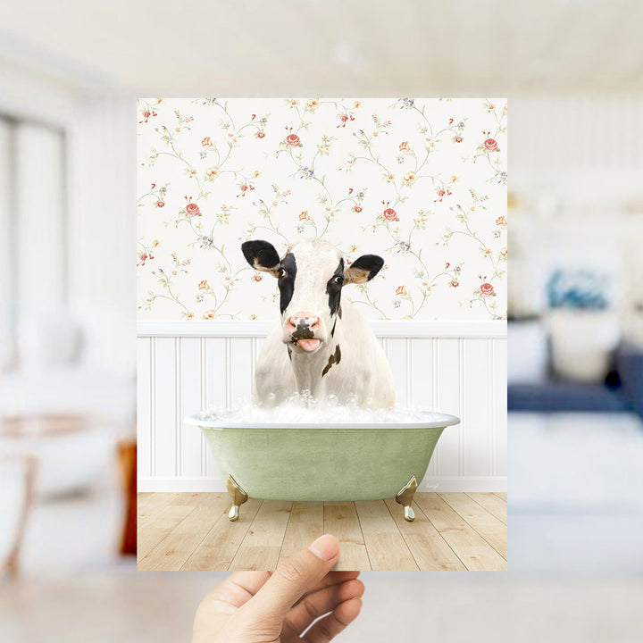 A cow is sitting in a green bathtub filled with water, surrounded by a floral wallpaper.