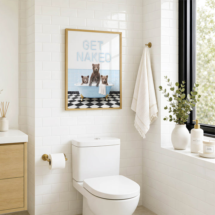 A bathroom with a white toilet, a framed poster of bears in a bathtub, and a window with greenery on the sill.