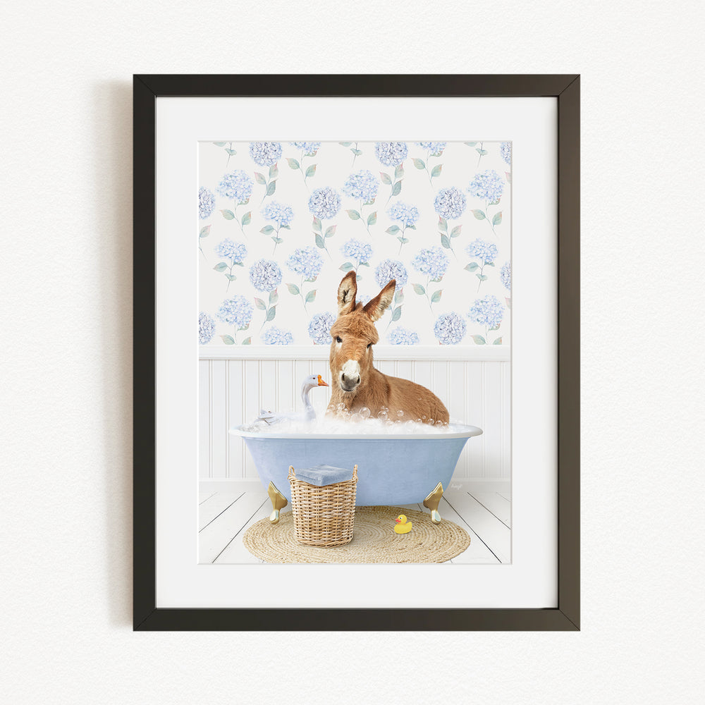 A donkey is sitting in a blue bathtub filled with bubbles, surrounded by rubber ducks and a basket.