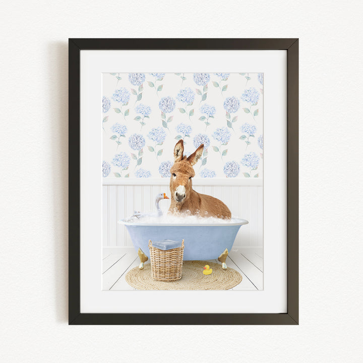 A donkey is sitting in a blue bathtub filled with bubbles, surrounded by rubber ducks and a basket.