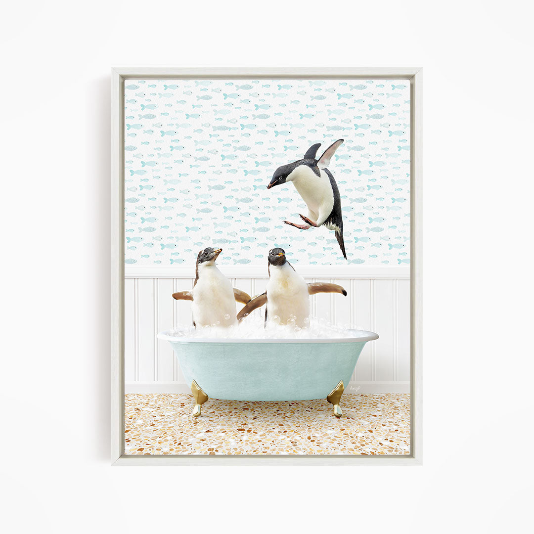 A framed image depicting two penguins sitting in a bathtub, with one penguin jumping out of the tub.